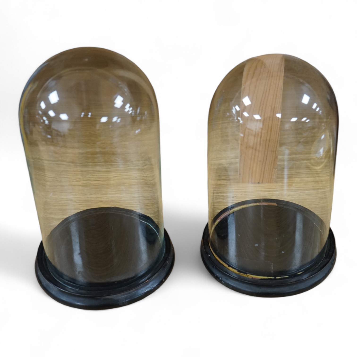 Two glass clock domes, tallest 23cm. Condition - fair